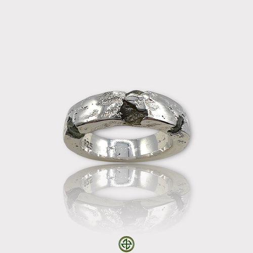 A silver ring featuring a raw peridot gemstone with a textured band.