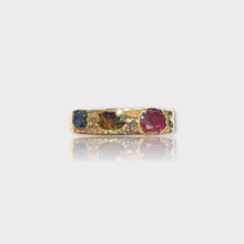 A gold vermeil band ring featuring a raw peridot gemstone alongside rubies and other tourmalines.