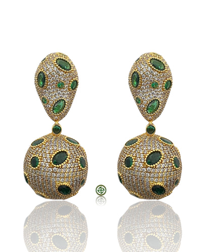 Pair of gold earrings with green gemstones on a white background