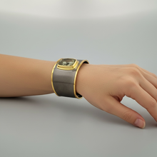 Luxury green amethyst cuff bangle crafted in black rhodium plated 925 sterling silver with thick 18K gold vermeil bezel. Elegant wide statement bracelet adjustable for 16–17 cm wrists.
