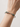 Alligator bangle worn on a wrist, showing the facing animal heads and green zirconia details across the top of the wrist.
