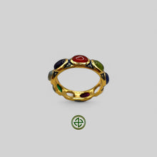 A gold-colored ring featuring a series of multicolored semi-precious gemstones arranged in a nestled pattern with pale blue enamel detailing.